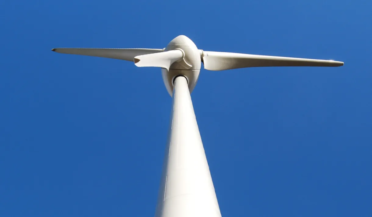 A wind turbine with as blue sky in the background - Scotland’s Our Power campaign urges Holyrood parties to ensure communities benefit from the renewable energy boom through public investment, jobs, and local ownership.