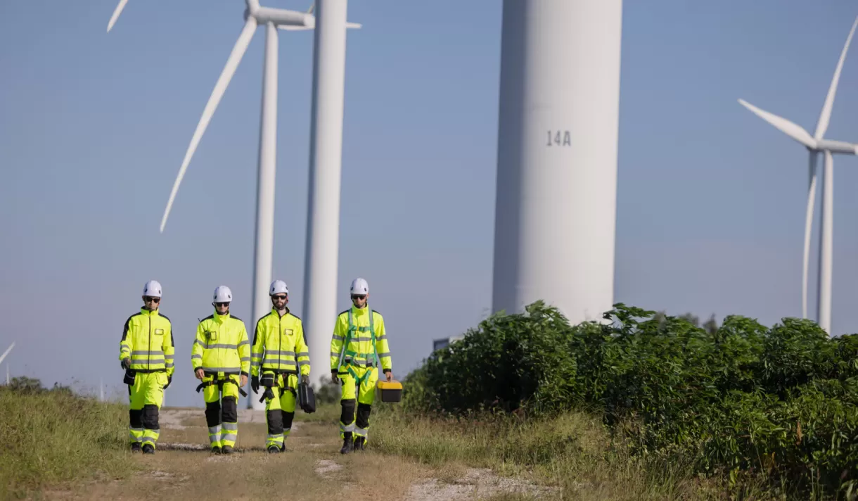 Workers walking together with wind turbines in the background
