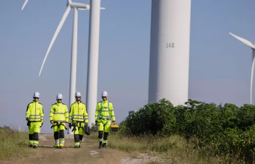 Workers walking together with wind turbines in the background