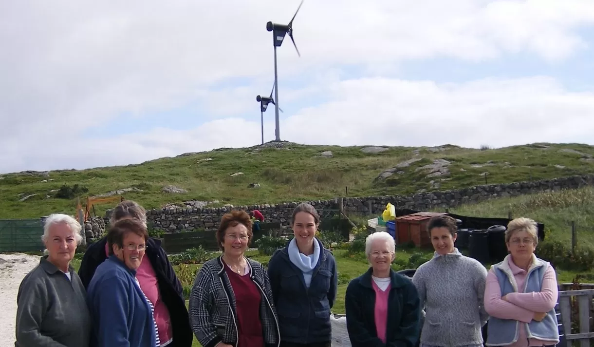 A group standing in front of a wind turbine. A parliamentary briefing