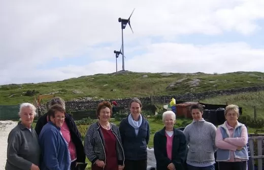 A group standing in front of a wind turbine. A parliamentary briefing